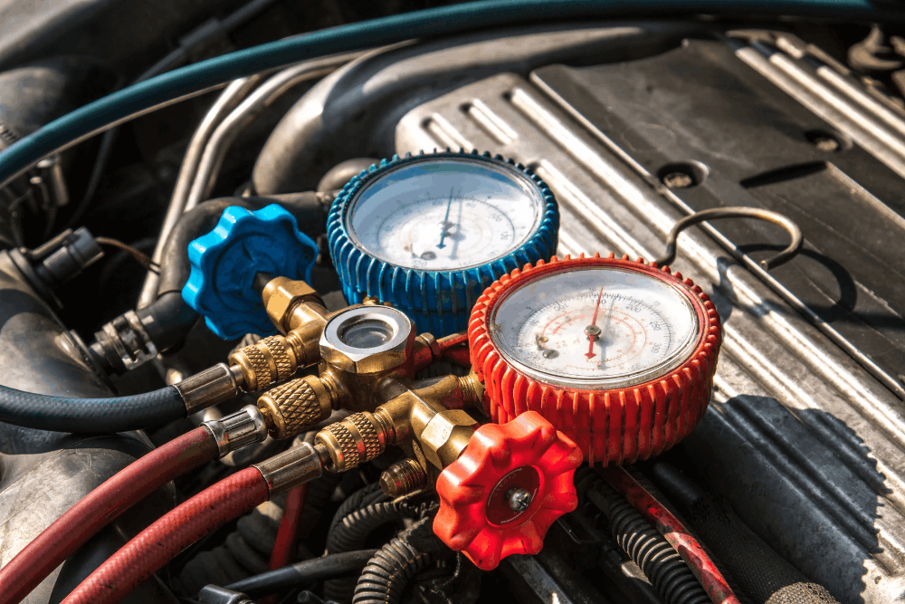 Car a/c service, auto repair in New Braunfels, TX at Clark's Auto Service. Close-up image of a professional A/C manifold gauges connected to a vehicle during automotive air conditioning diagnostics, refrigerant testing, and A/C system service.